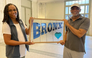 A happy couple show one of two custom Bronx panels for their front windows.